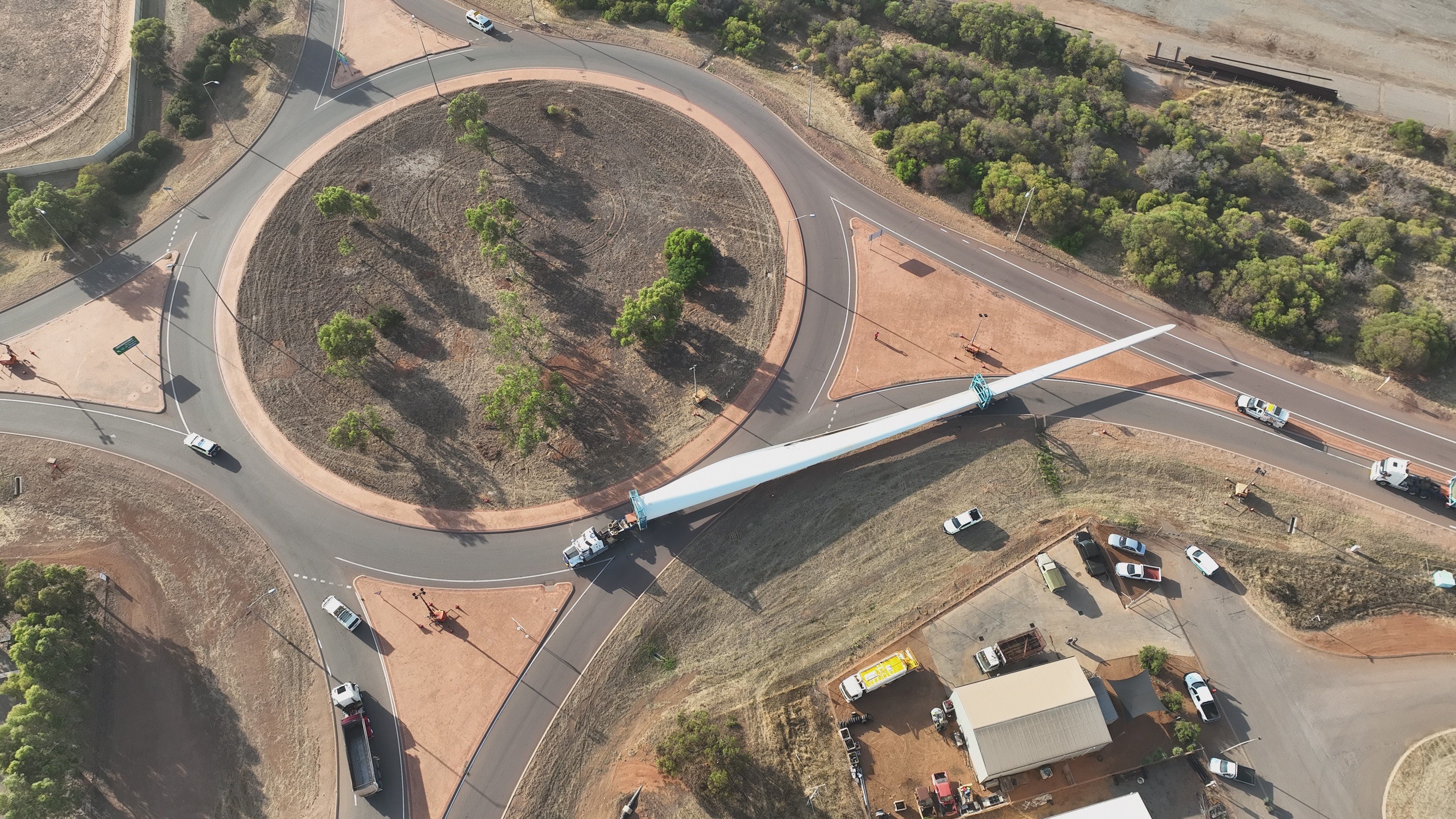 aerial view of a Heavy Vehicle transporting a large wind blade through a roundabout