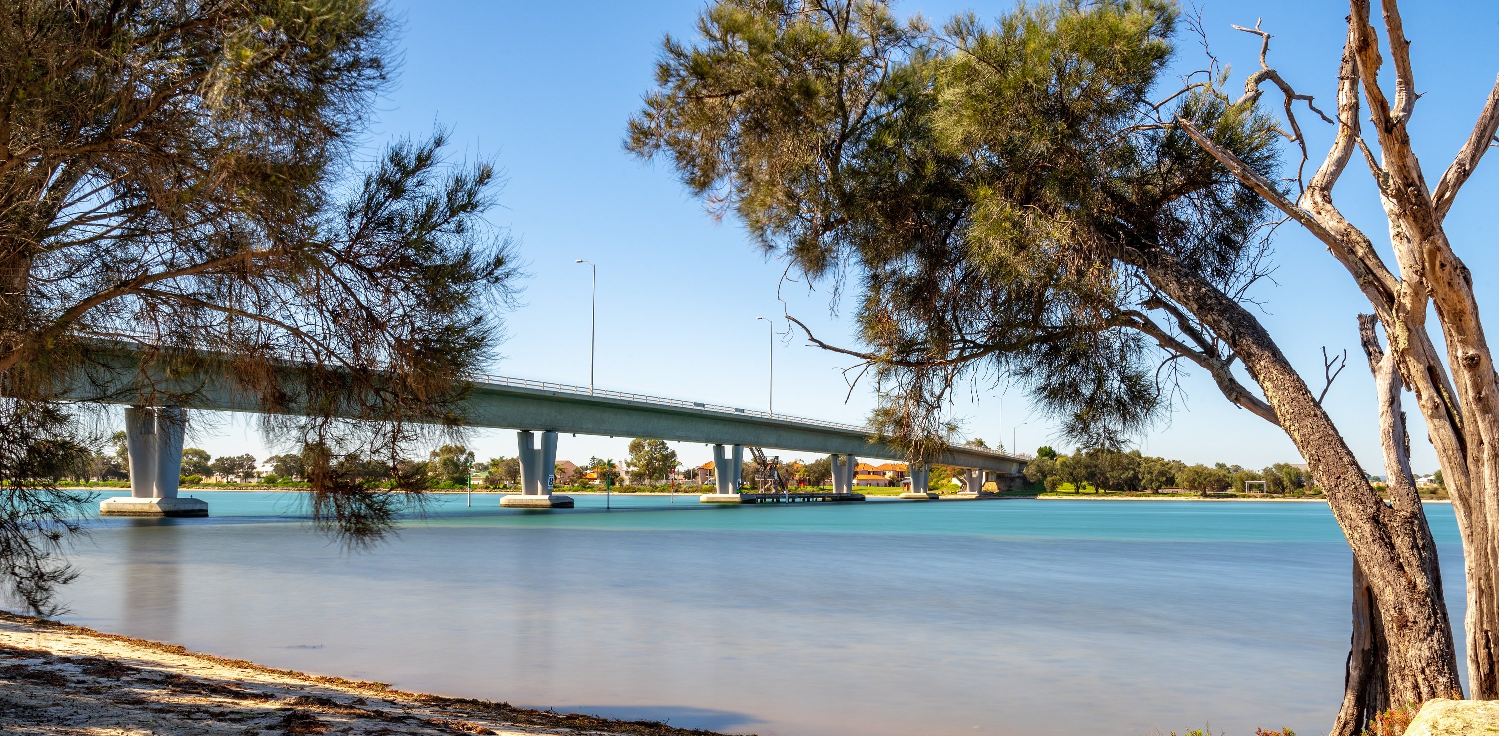 Mandurah Bridge over river surrounded by trees